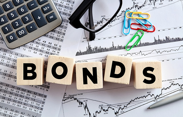 The word bonds on wooden cubes with office desktop. Business finance stock exchange concept.