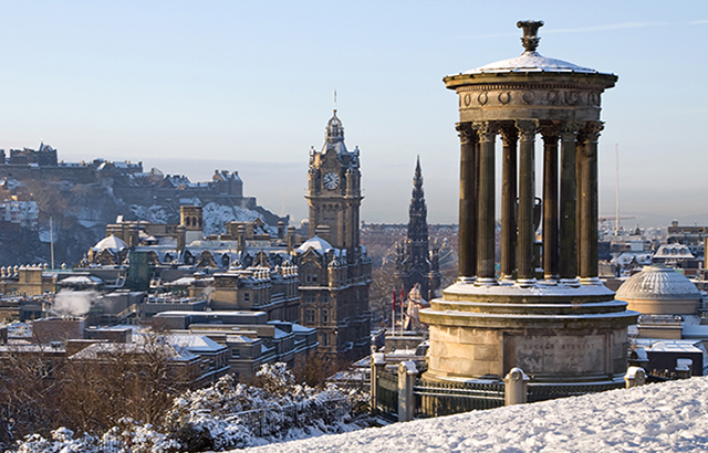 Edinburgh City and Castle viewed from Calton Hill on a beautiful winter morning with the Dugald Stewart monument in the foreground and the castle, Scott monument and Balmoral clock tower in the background.