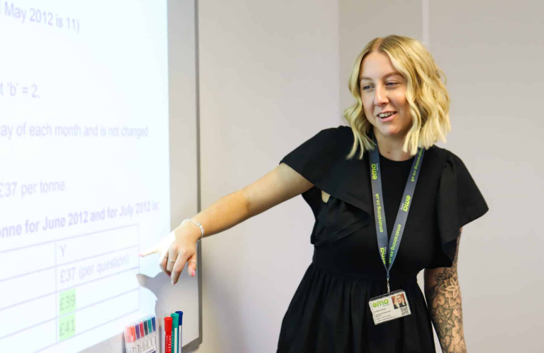 EMA's Accountancy Trainer and Mentor, Lottie, pointing at board