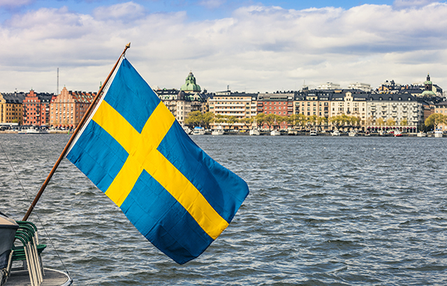 Stockholm view to downtown with a Swedish flag on the waterfront.